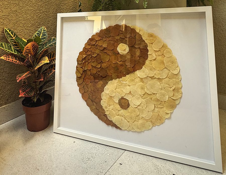 Quadro sistêmico com yin-yang feito de pétalas, em moldura branca